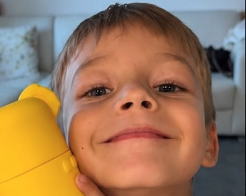 Child holding a yellow KOA Tummy Time container